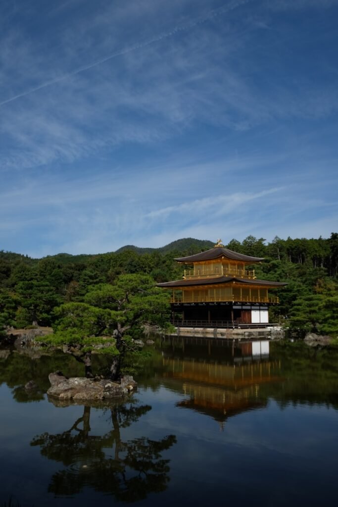 a building sitting on top of a lake next to a forest