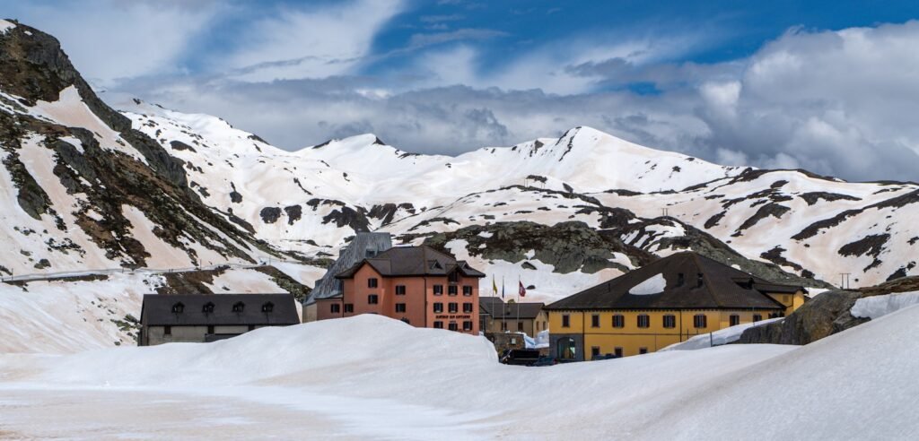 A snow covered mountain with a building in the foreground