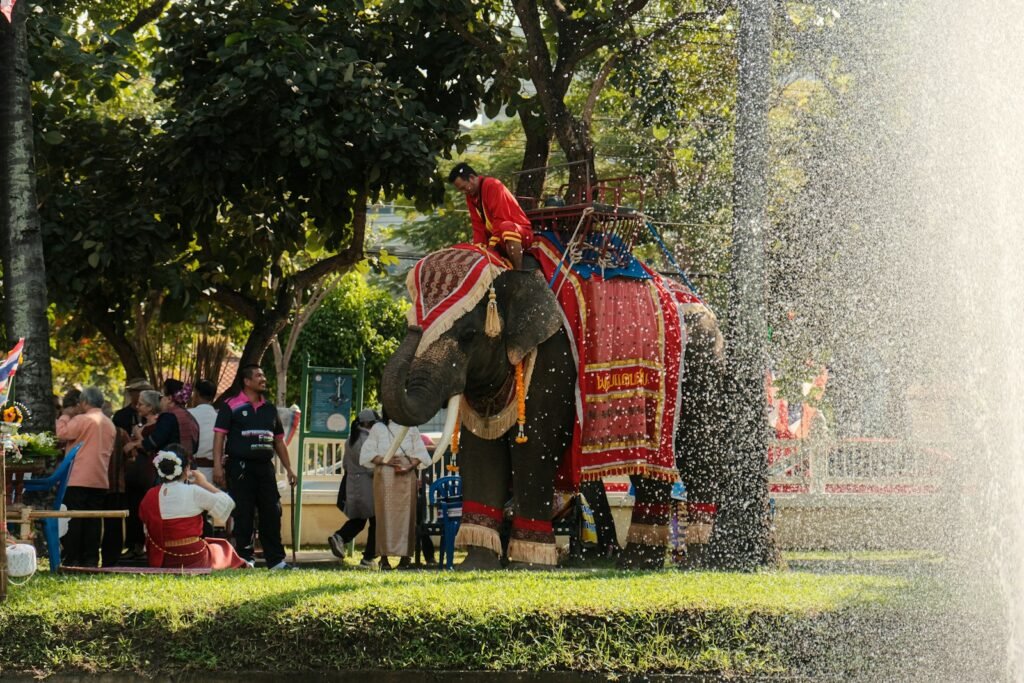 An elephant spraying water on a crowd of people